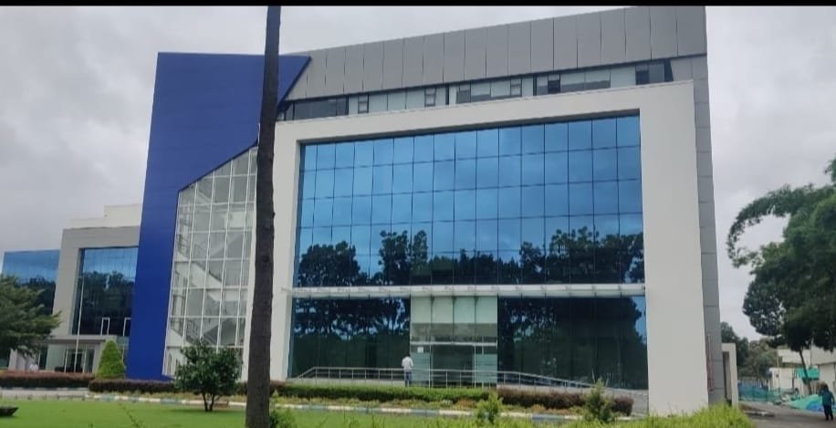 Modern Blue Glass Office Building, exterior works by Dhrithi Infra